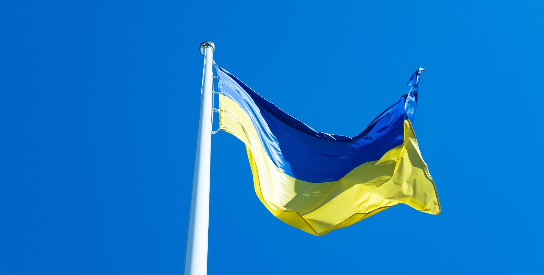 ukrainian flag flagpole waving wind against blue sky background 3